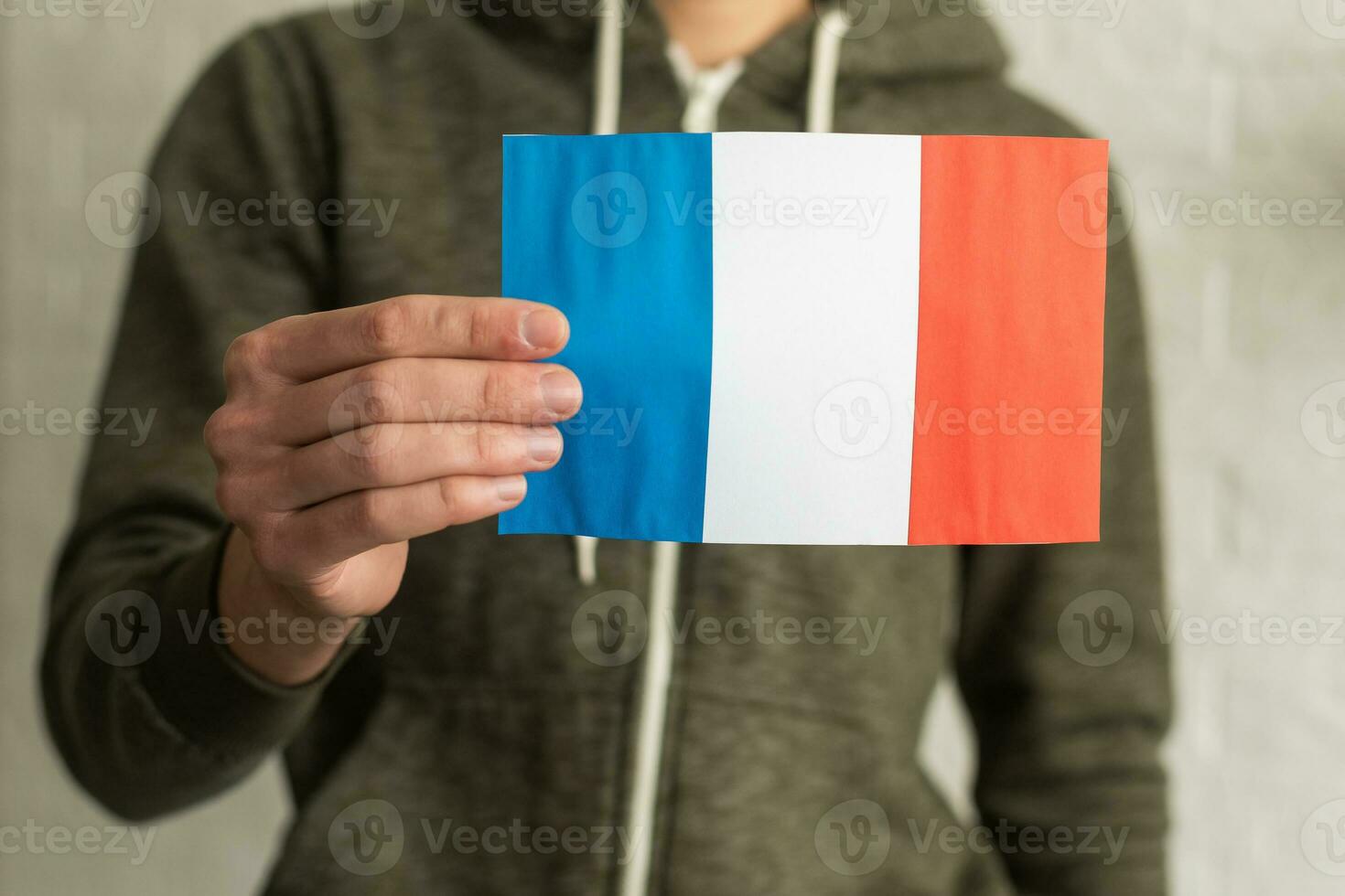 close up hand holding french flag on studio isolated white background photo