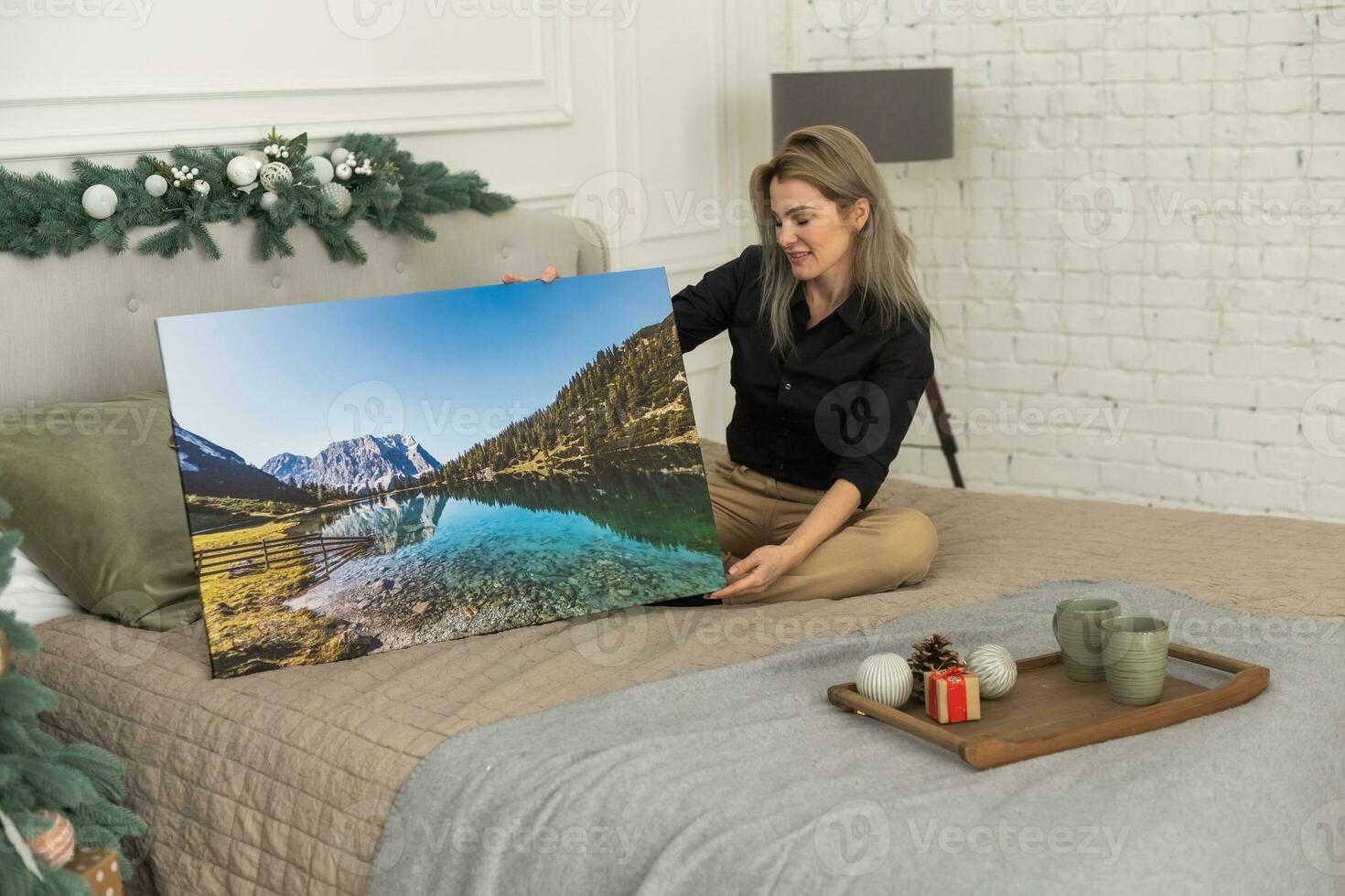 Canvas prints. A woman holding photograph with gallery wrap. Landscape photo printed on glossy synthetic canvas and stretched on wooden stretcher bar