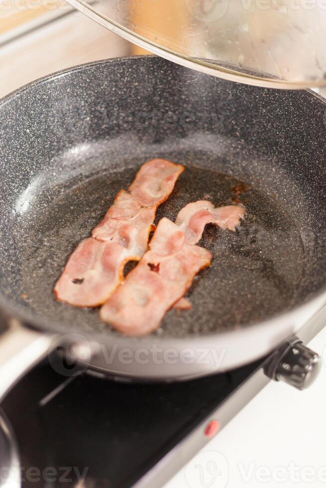 frito tocino en el pan para un deliciosa desayuno. sano Mañana en acogedor interior, delicioso hogar comida preparación. foto