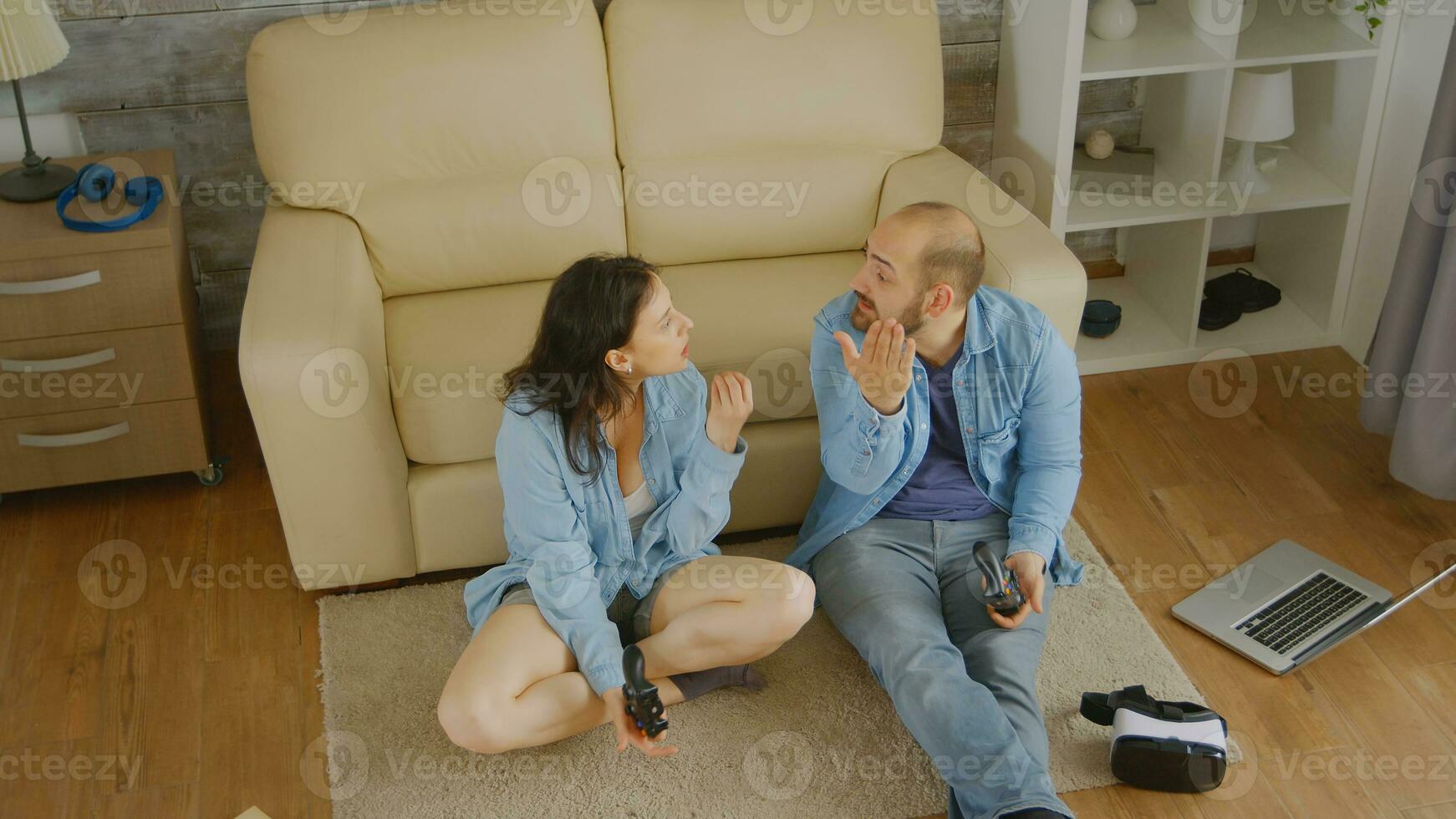 Top view of husband and wife fighting while playing video games on console photo
