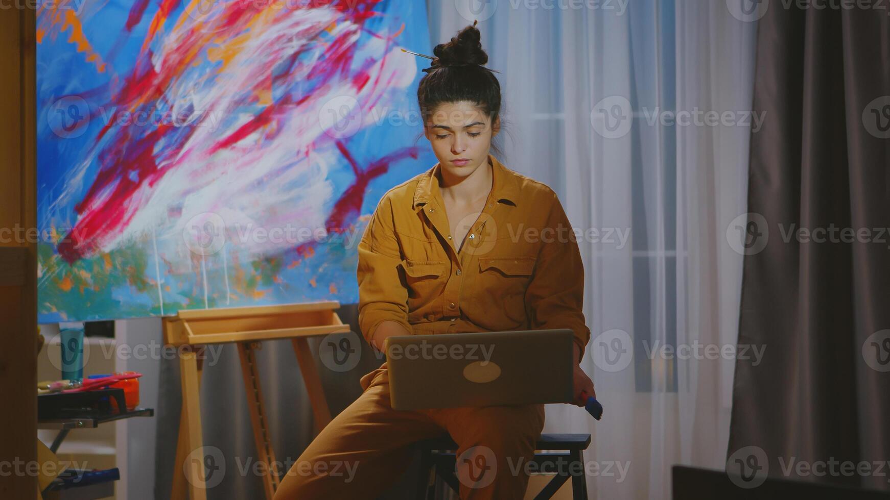 Painter searching inspiration on laptop in art studio. photo