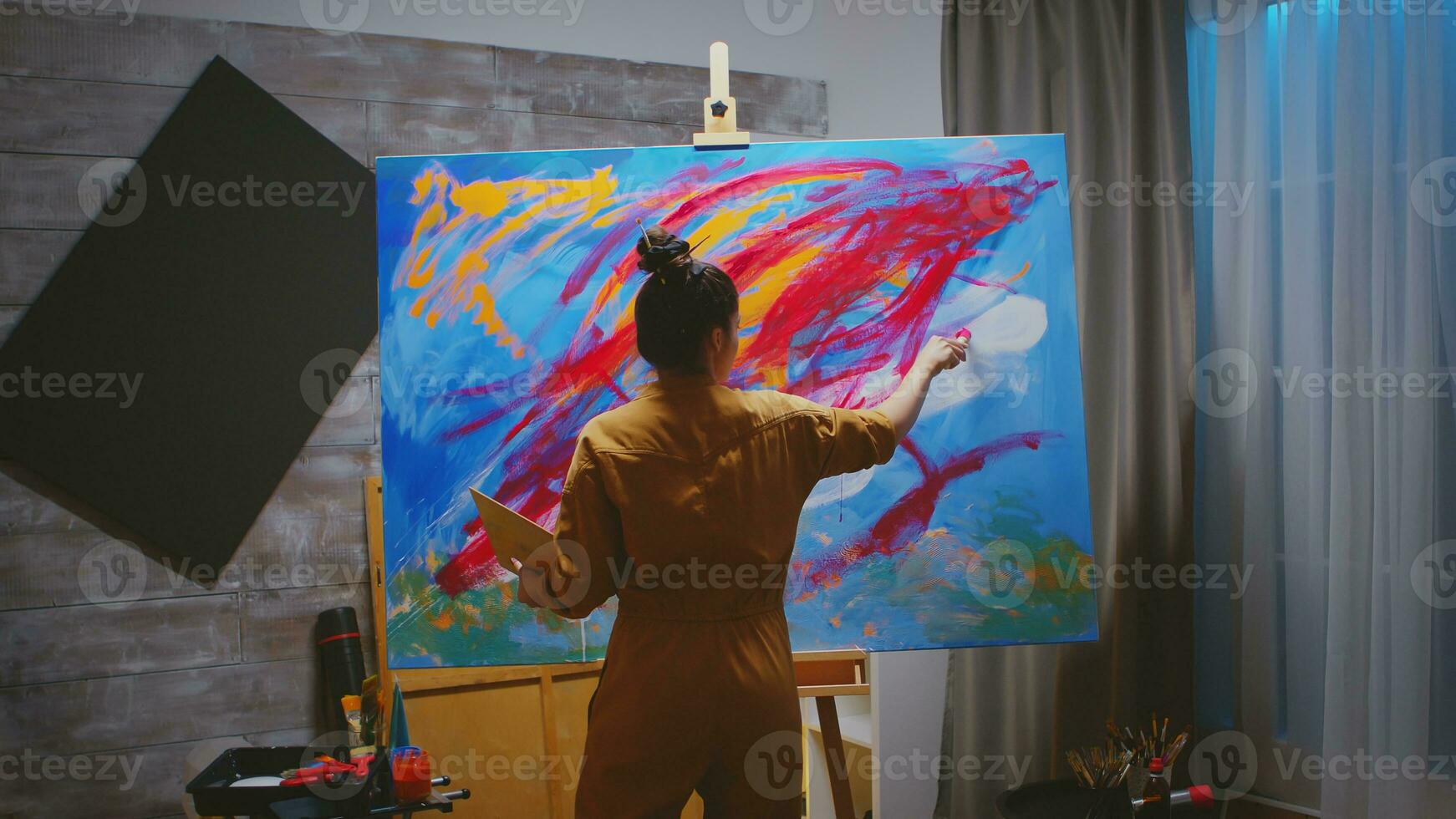 Successful young woman creating a masterpiece painting. photo