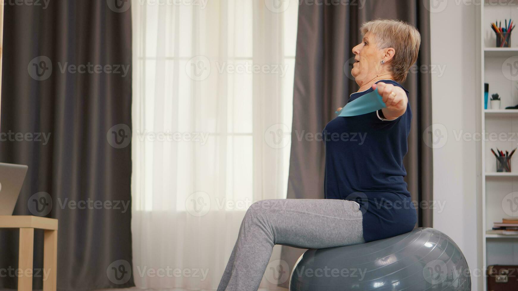 mayor mujer haciendo deporte en estabilidad pelota con resistencia banda pensionista antiguo mujer extensión aptitud vivo sano estilo de vida a Jubilación, formación a hogar ejercicio foto