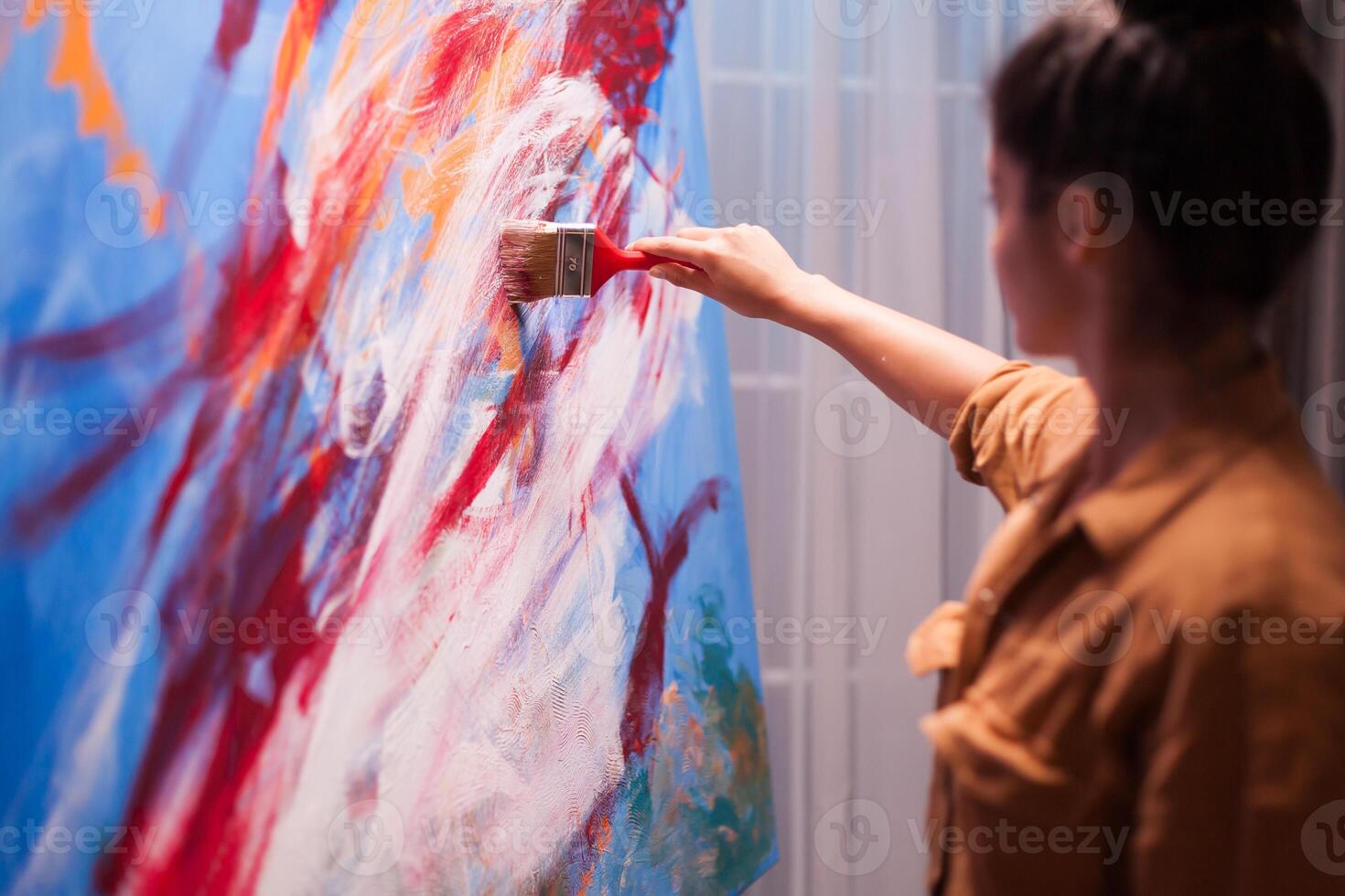 Woman relaxing in art studio painting on large canvas. Modern artwork paint on canvas, creative, contemporary and successful fine art artist drawing masterpiece photo