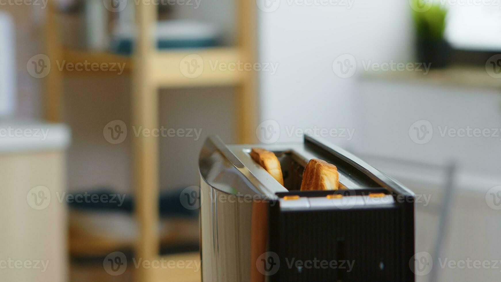 Roasting bread popping out of toaster in kitchen for breakfast. Bread preparation for delicous breakfast. Healthy morning in cozy interior, delicious home meal preparation photo