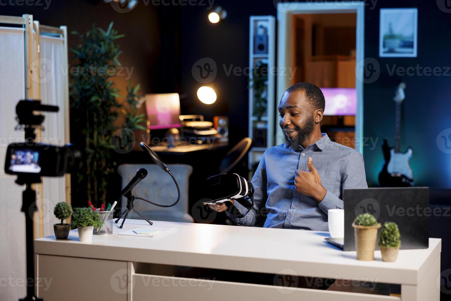 Tech influencer filming sponsored content, unboxing newly released VR glasses product to make fans buy it. Entertainer amazed by product, presenting impressive virtual reality headset to subscribers photo