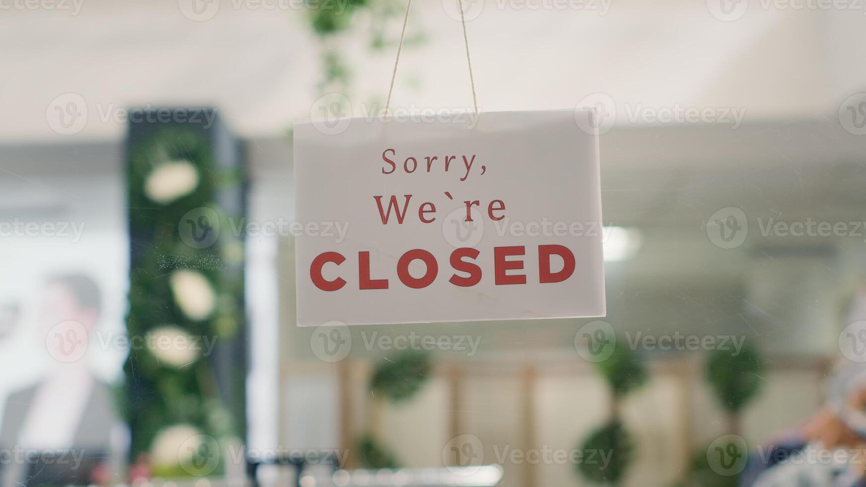 Sorry we are closed sign in empty clothing store in mall with fast fashion clothes following the latest trends. Message on fashion boutique door announcing customers that shop is closed photo