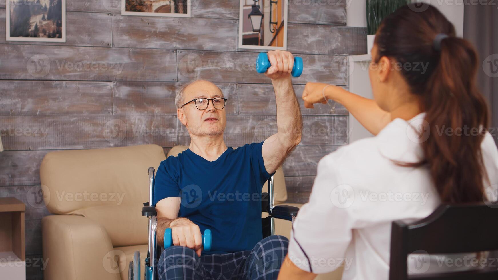 Senior man physiotherapy in wheelchair with help from medical worker. Disabled handicapped old person with social worker in recovery support therapy physiotherapy healthcare system nursing retirement home photo