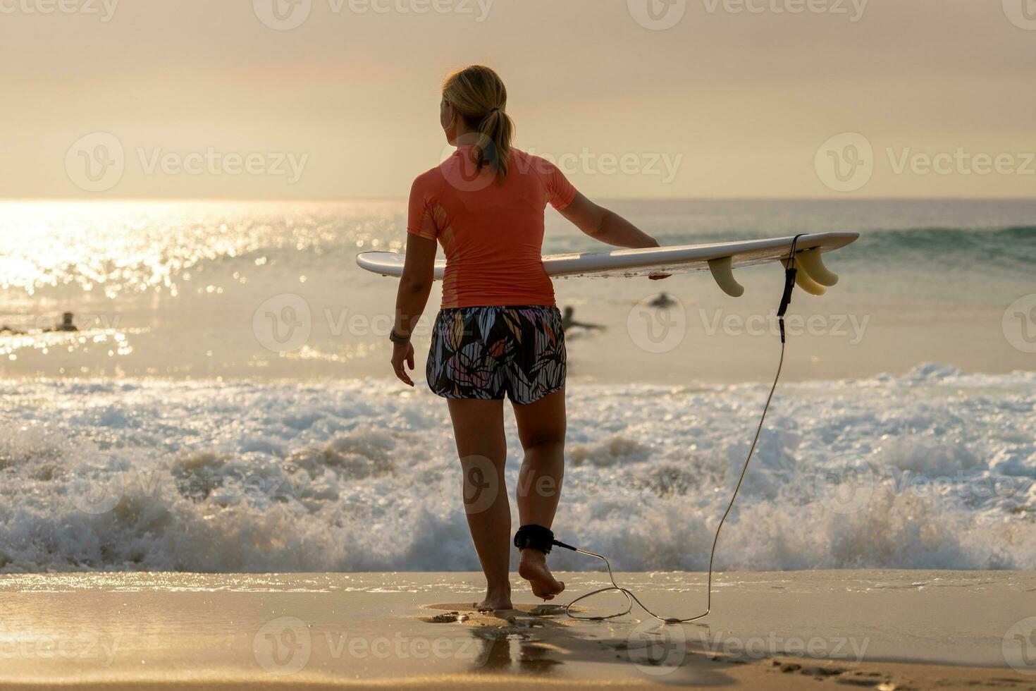 Surfer on her way into the water photo