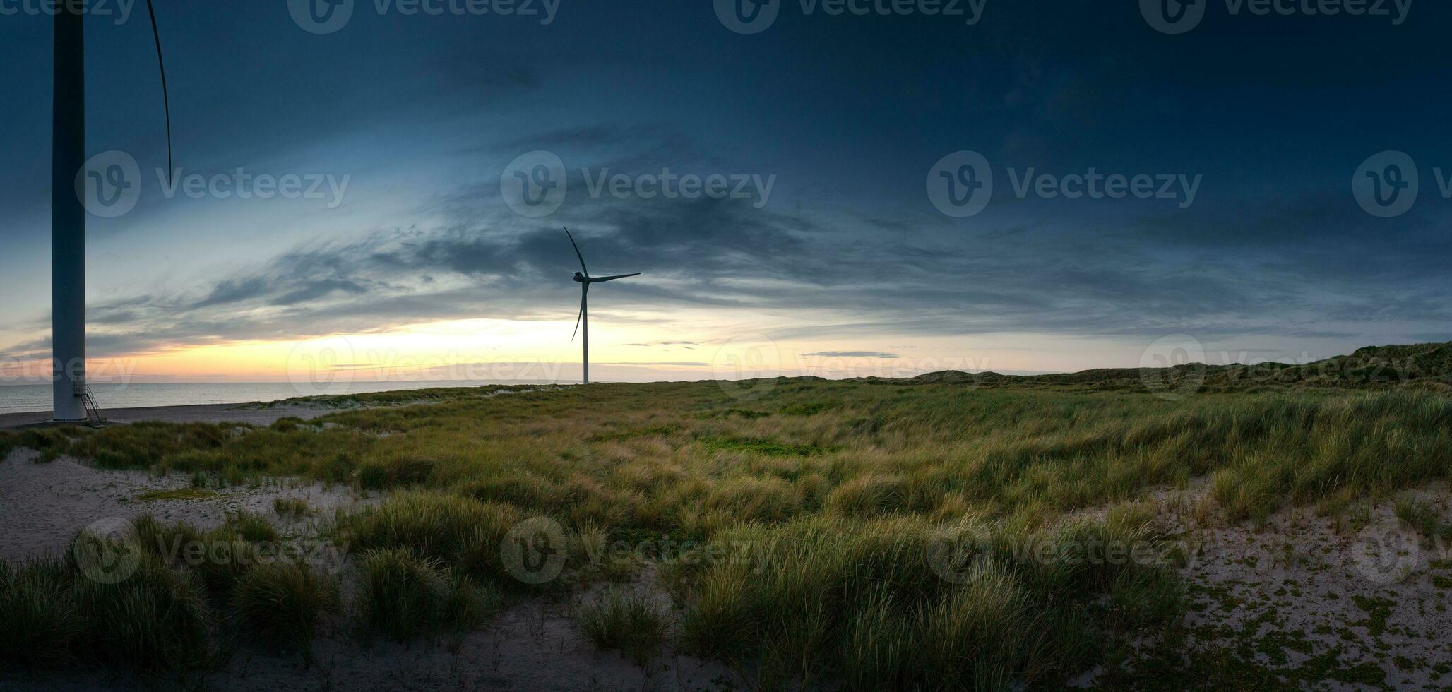 duna paisaje en Dinamarca en el norte mar costa a puesta de sol con viento turbinas foto