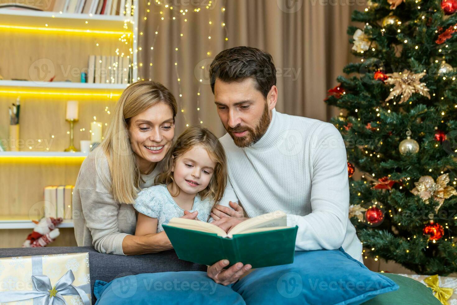 un joven familia gasta hora juntos en Navidad víspera. mamá y papá son leyendo un libro a el hija. foto