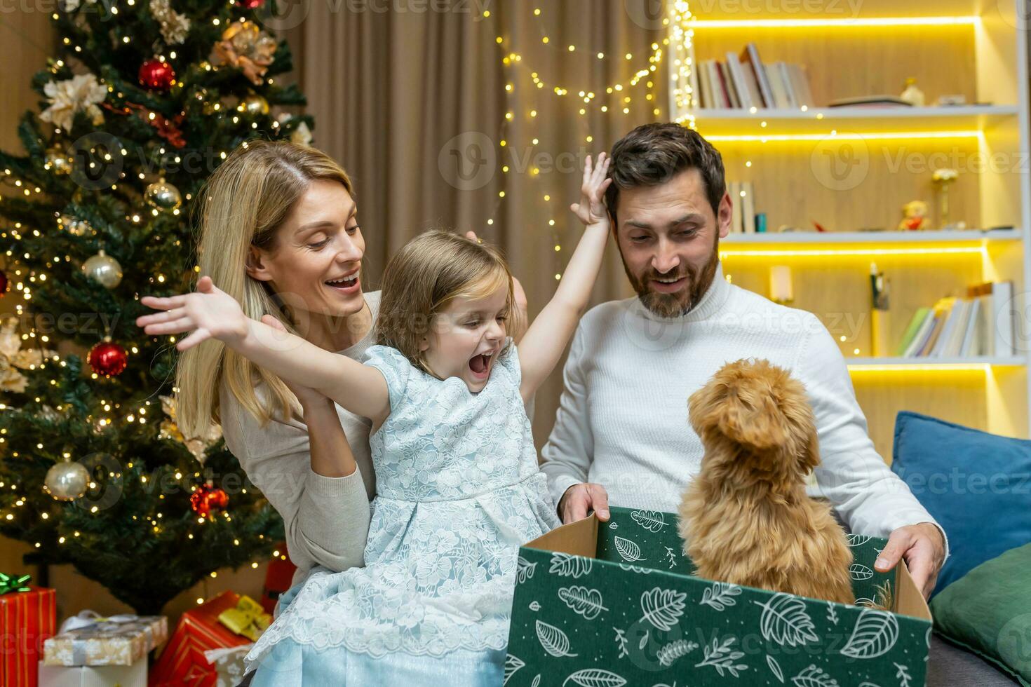 contento nuevo años familia para Navidad, marido y esposa con hija en el vivo habitación cerca el Navidad árbol, compartiendo regalos, dando un pequeño mascota maltipoo perro a el muchacha. foto
