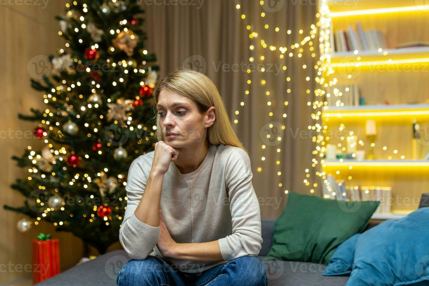 triste mujer solo a hogar para Navidad, sentado en sofá en vivo habitación Deprimido en nuevo año vacaciones. foto