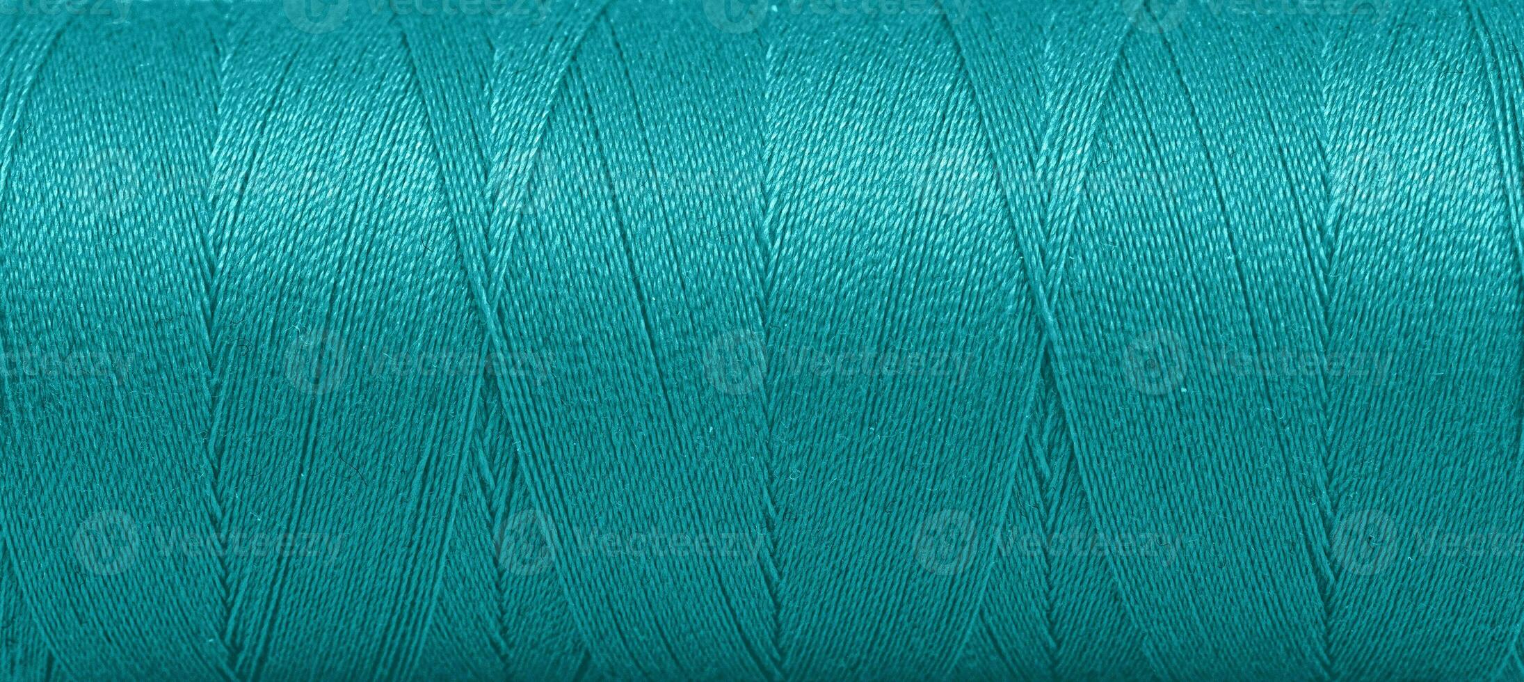 Texture of threads in a spool of green color on a white background photo