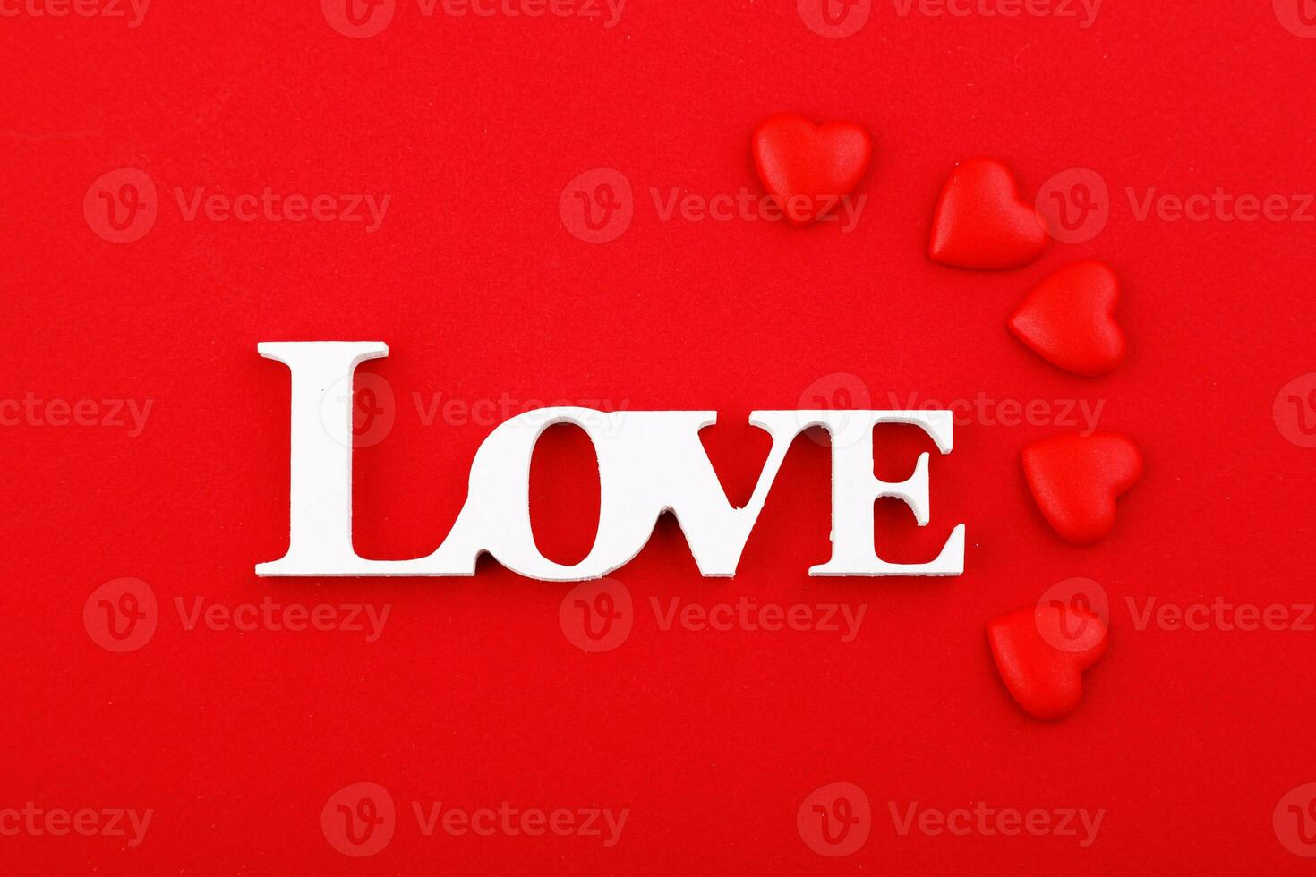 inscription love and red hearts on a red background photo