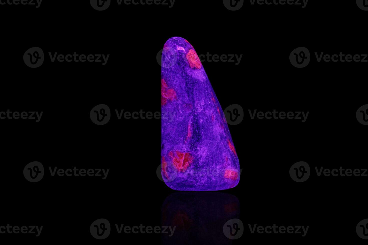 macro mineral stone ruby under ultraviolet light on a black background photo
