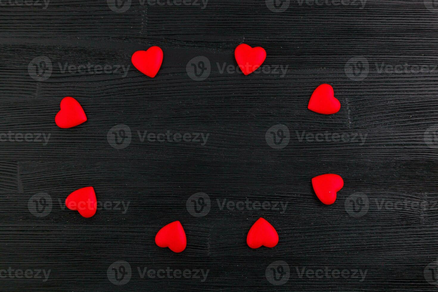 ed hearts on black wooden background photo