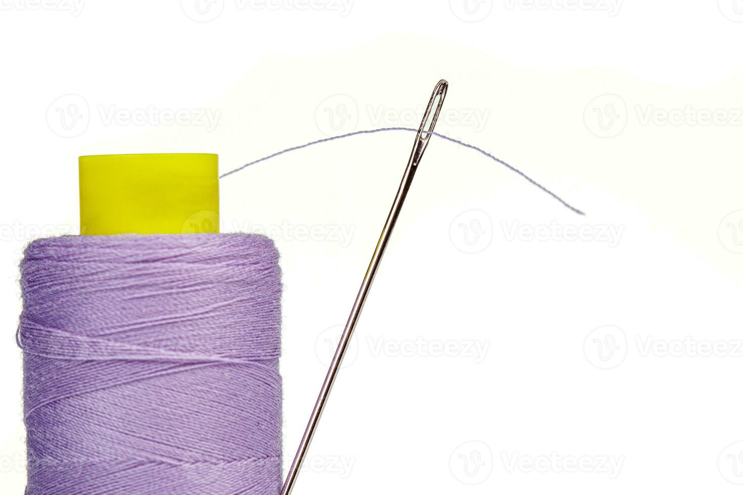 Macro skein of thread purple colors with a needle on a white background photo