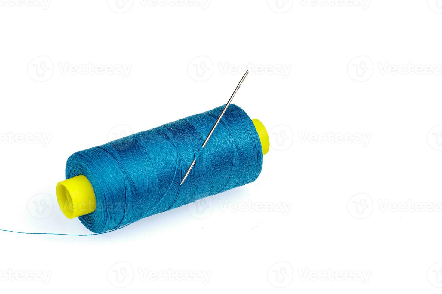 macro madeja de azul hilo con un aguja en un blanco antecedentes foto