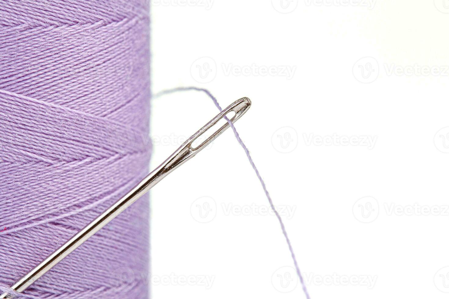 Macro skein of thread purple colors with a needle on a white background photo