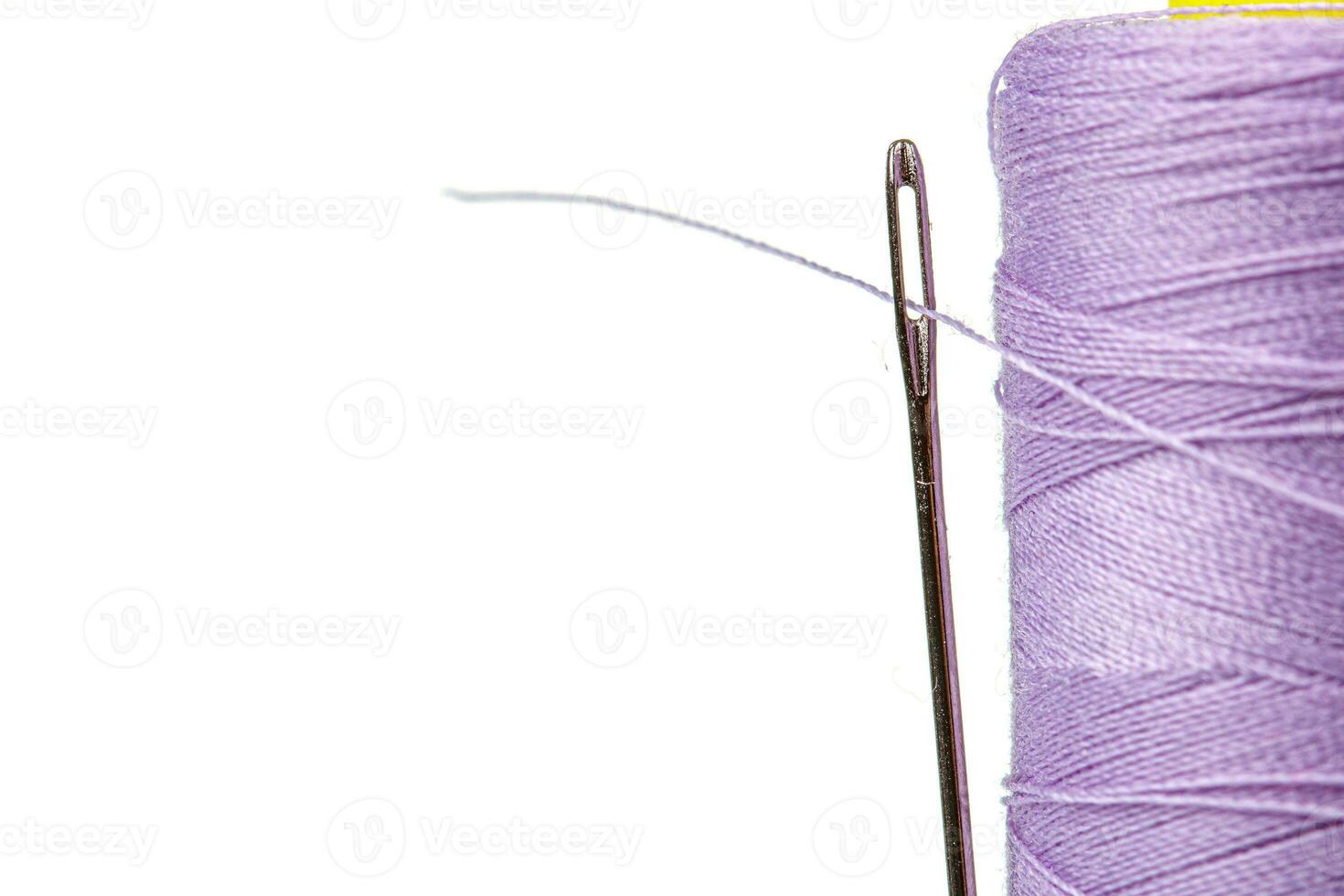 Macro skein of thread purple colors with a needle on a white background photo