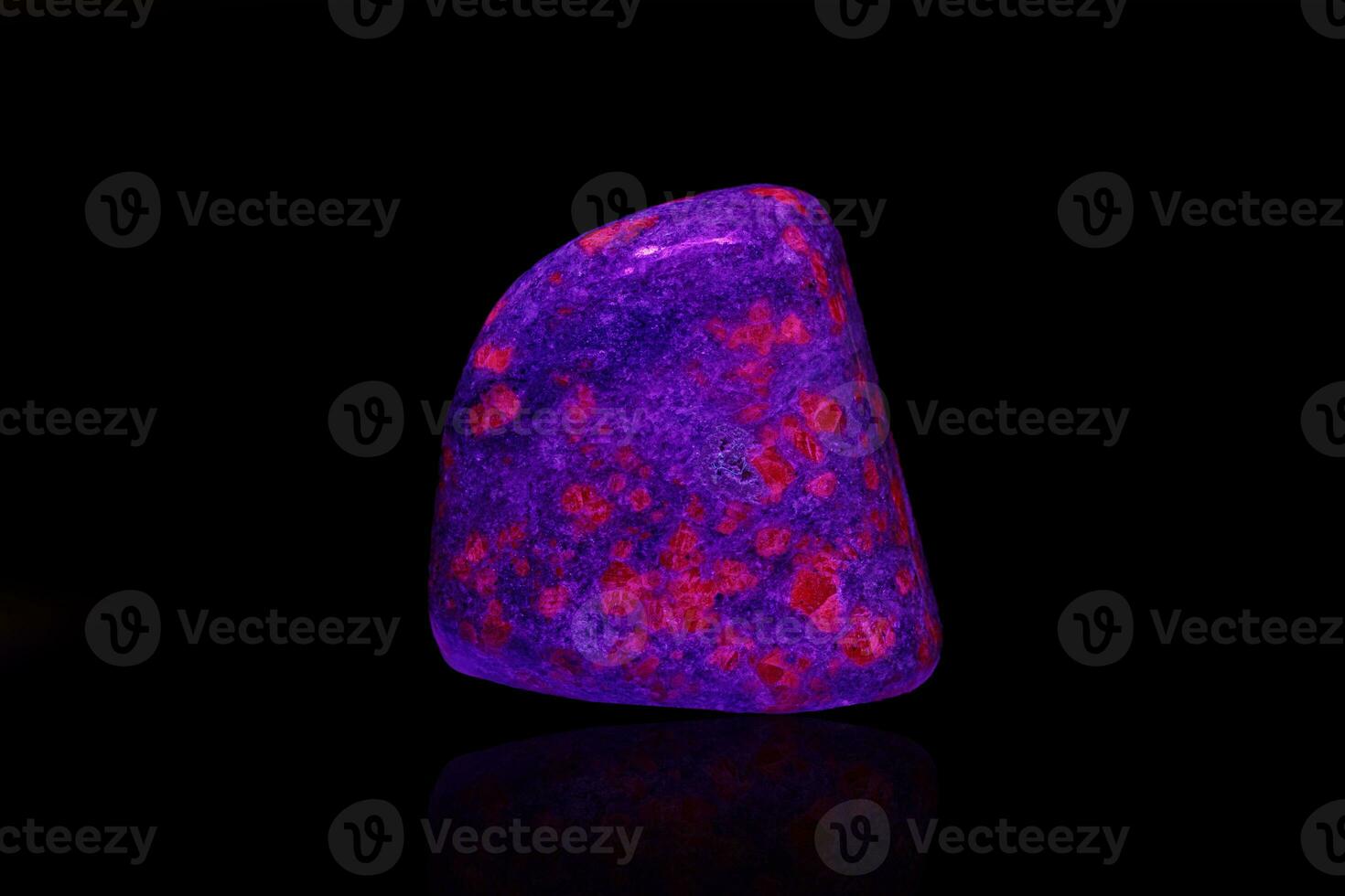 macro mineral stone ruby under ultraviolet light on a black background photo