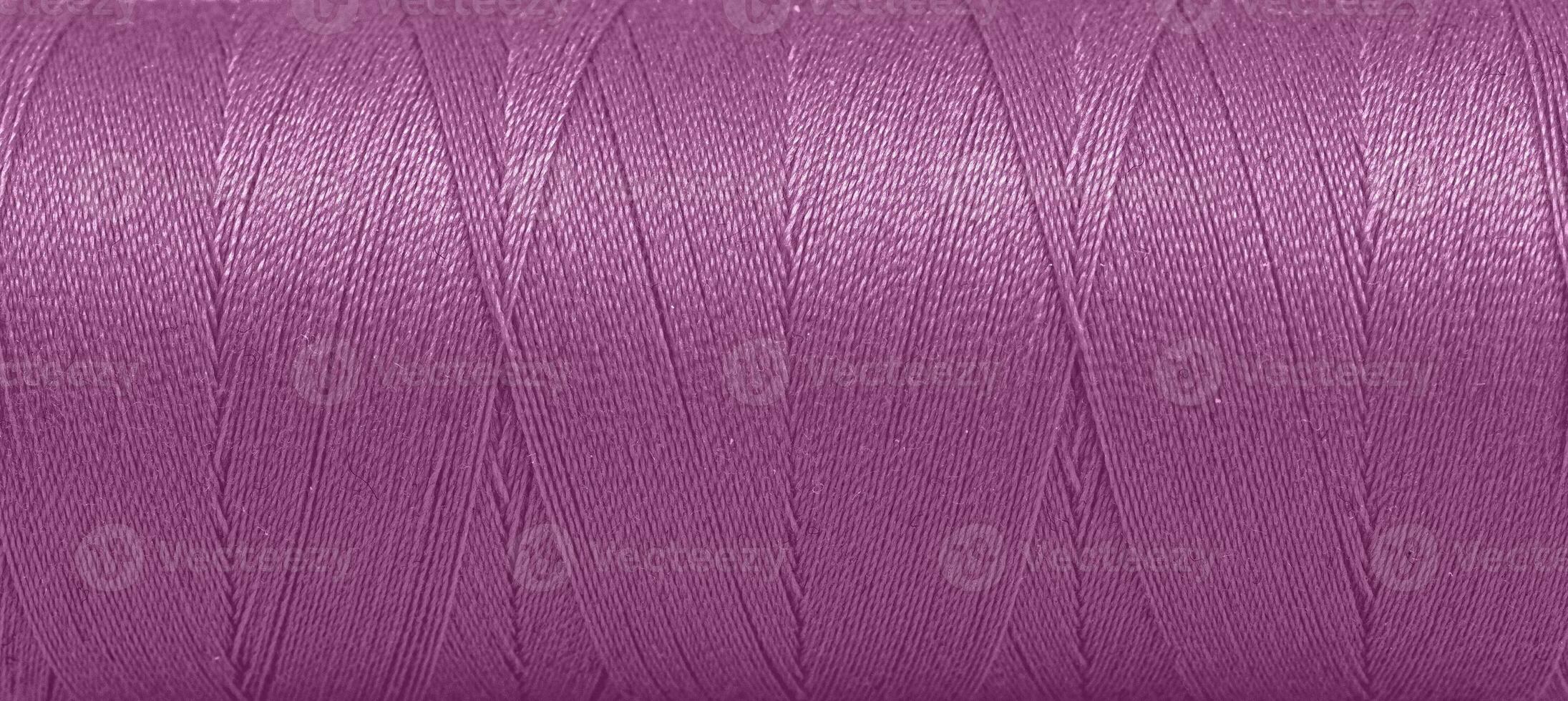 textura de hilos en un carrete de púrpura color en un blanco antecedentes foto