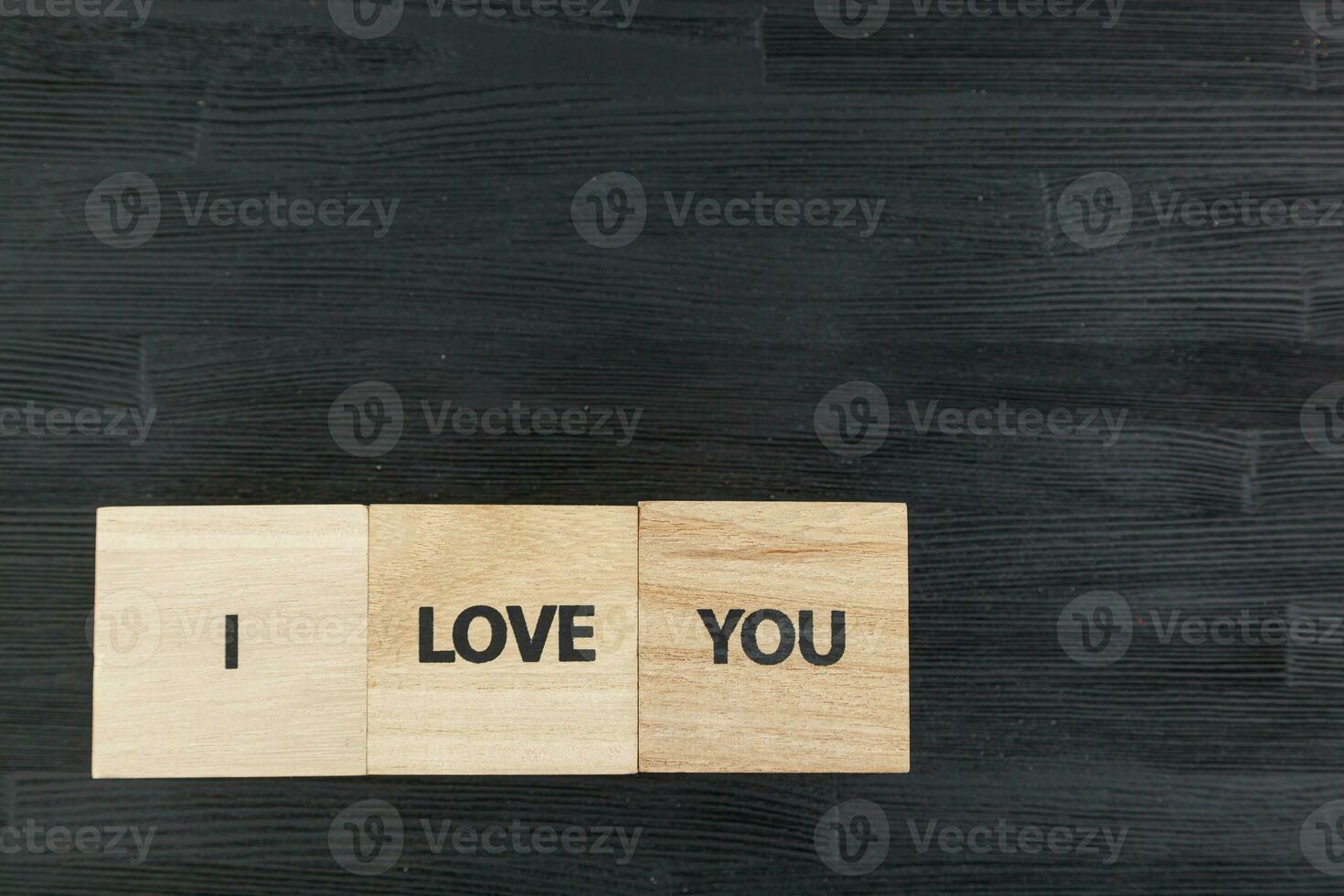 inscription I love you on a black wooden background photo