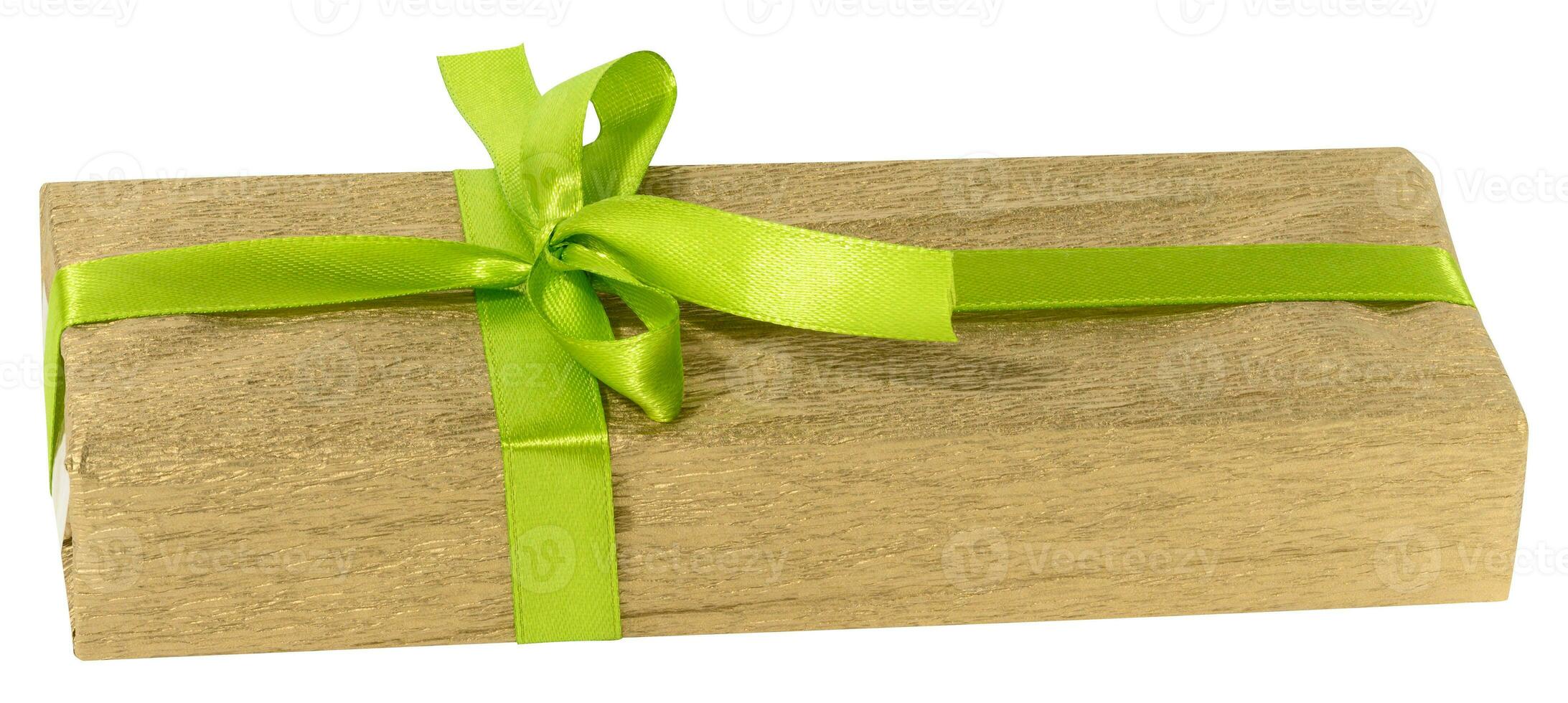 Box is wrapped in yellow gift wrapping and green ribbon on a white isolated background photo