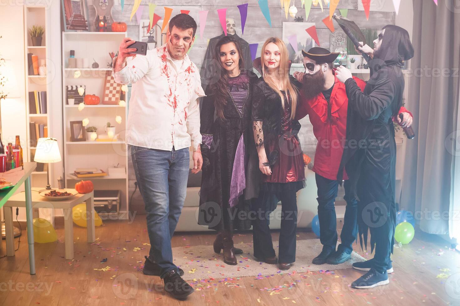 Spooky man taking a selfie with his friends at halloween party. photo