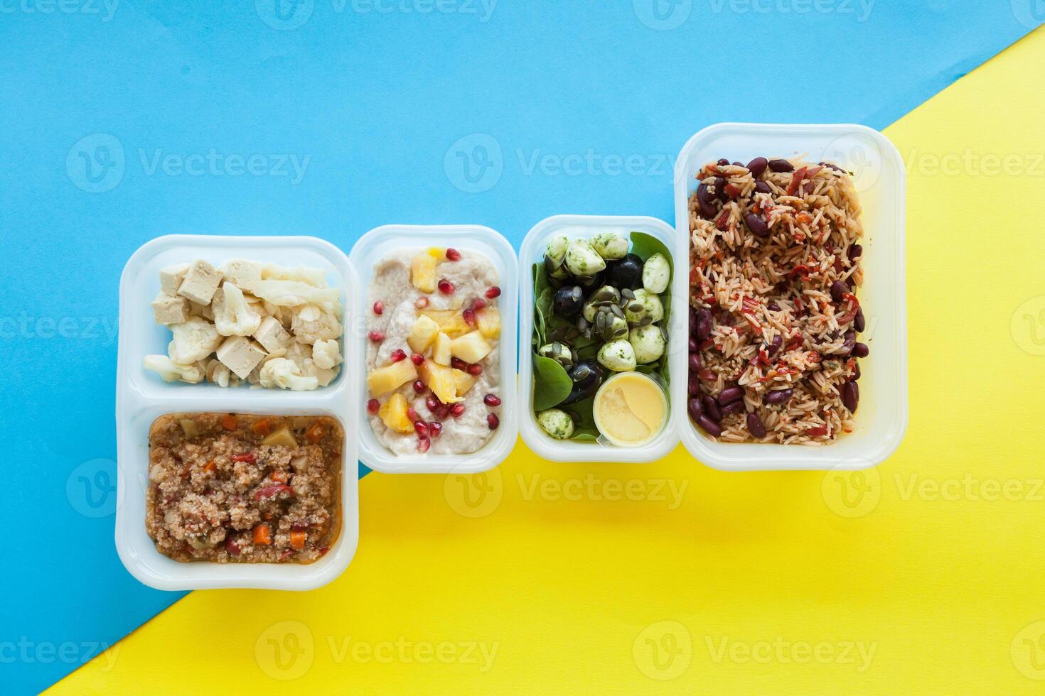Healthy food delivery over yellow and blue background. Take away of natural organic fitness nutrition for diet. Top view, flat lay. Packed daily meals. photo