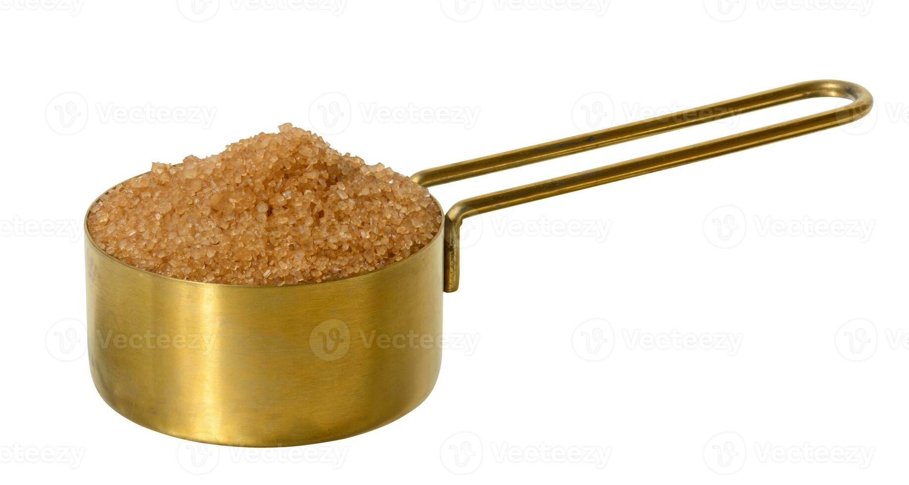 Brown cane sugar granules in a metal bowl on a white isolated background photo