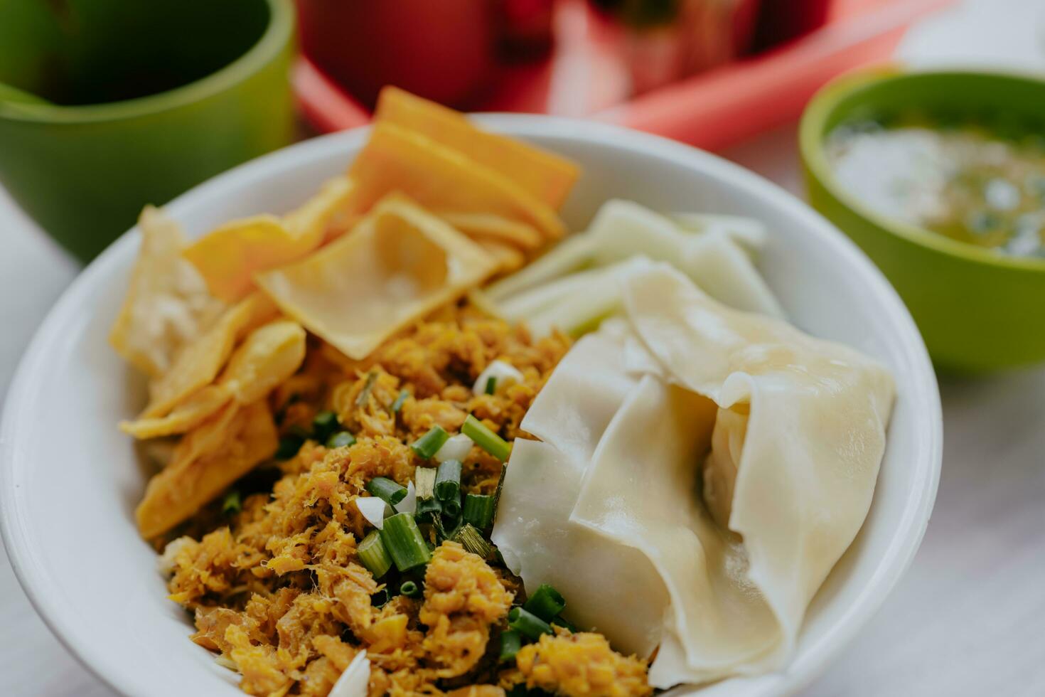 Bowl of Chicken Noodles on wooden table with chili sauce, sauce and meat sauce. photo