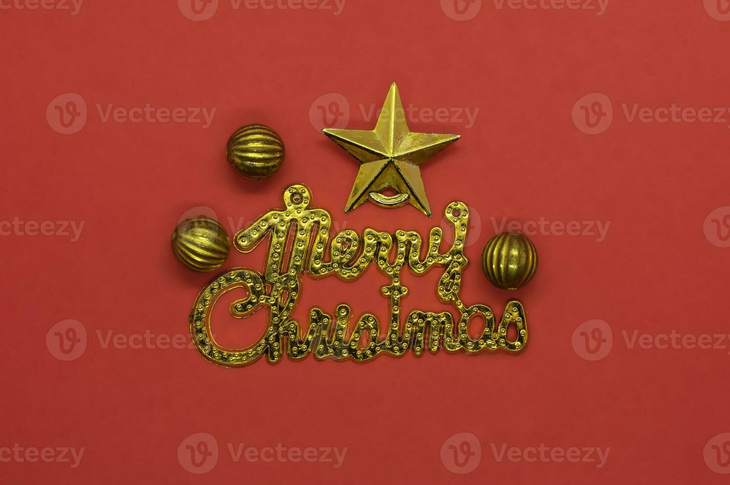Merry Christmas lettering greeting card with gold star and baubles on red background photo