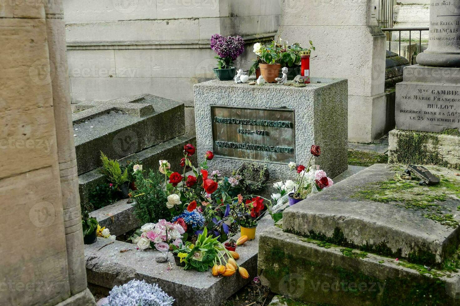 a stone grave site with flowers photo