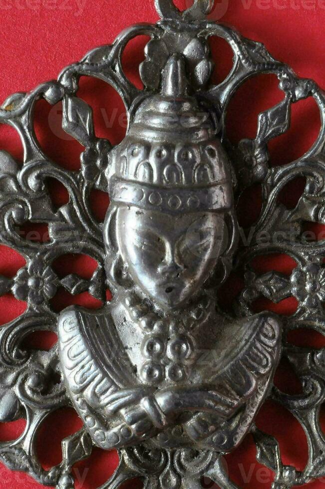a silver pendant with a buddha head on it photo