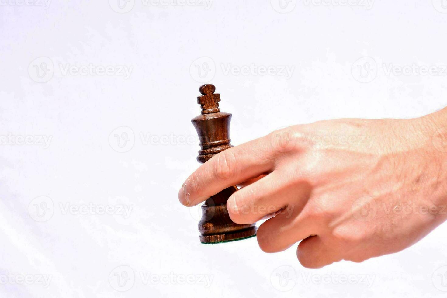 a hand holding a chess piece on a white background photo