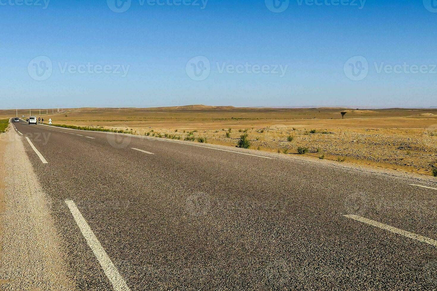 a long empty road in the middle of the desert photo