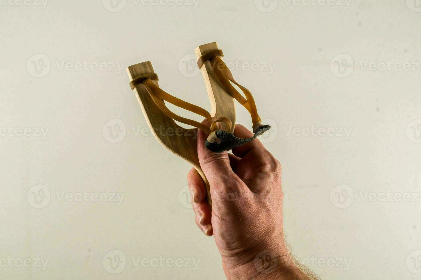 a hand holding a slingshot photo