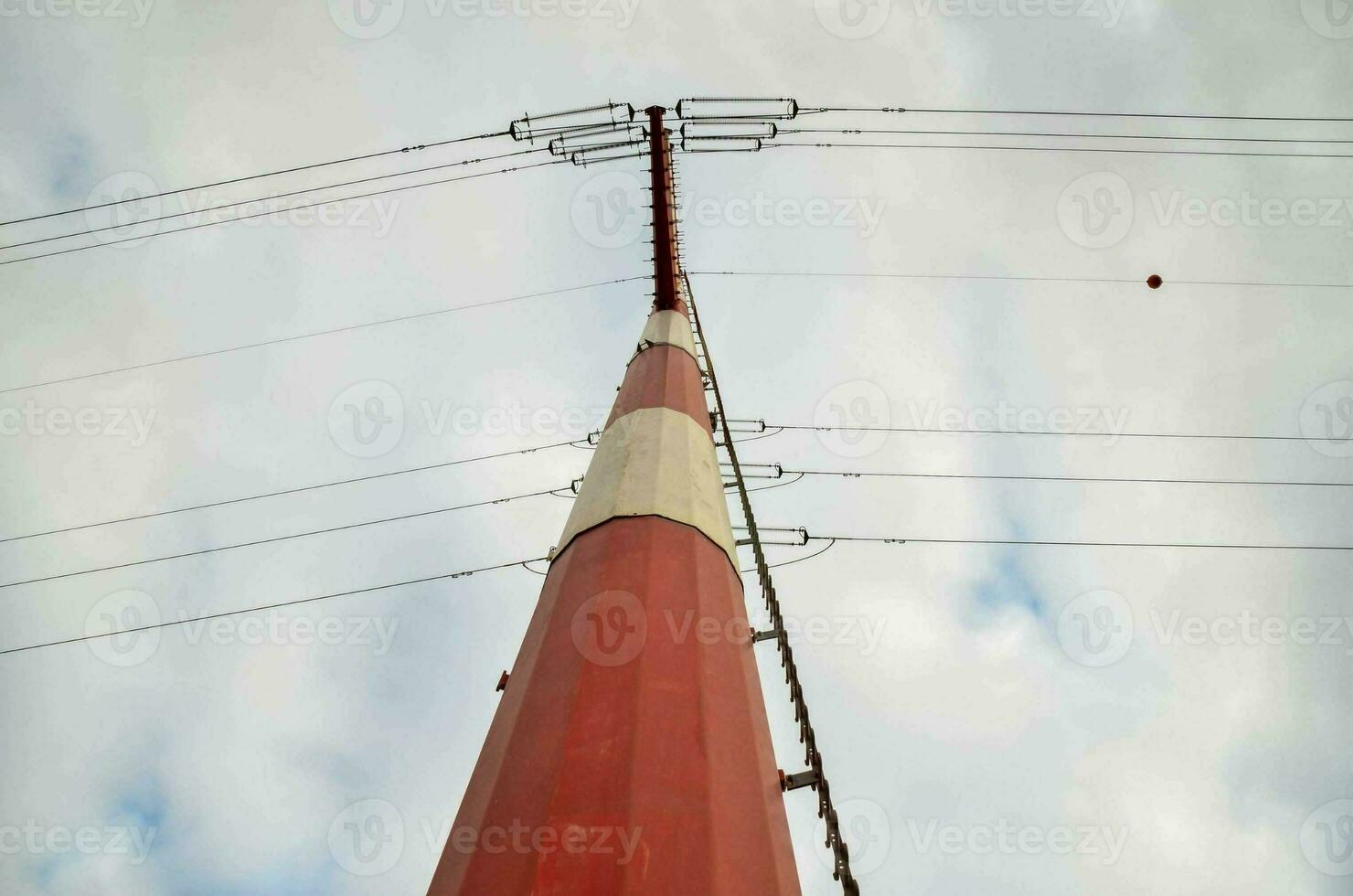 a red and white pole with wires on top photo