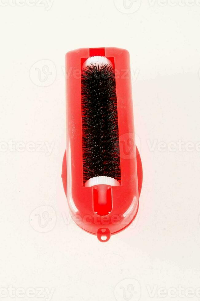 a red container with a black brush inside photo