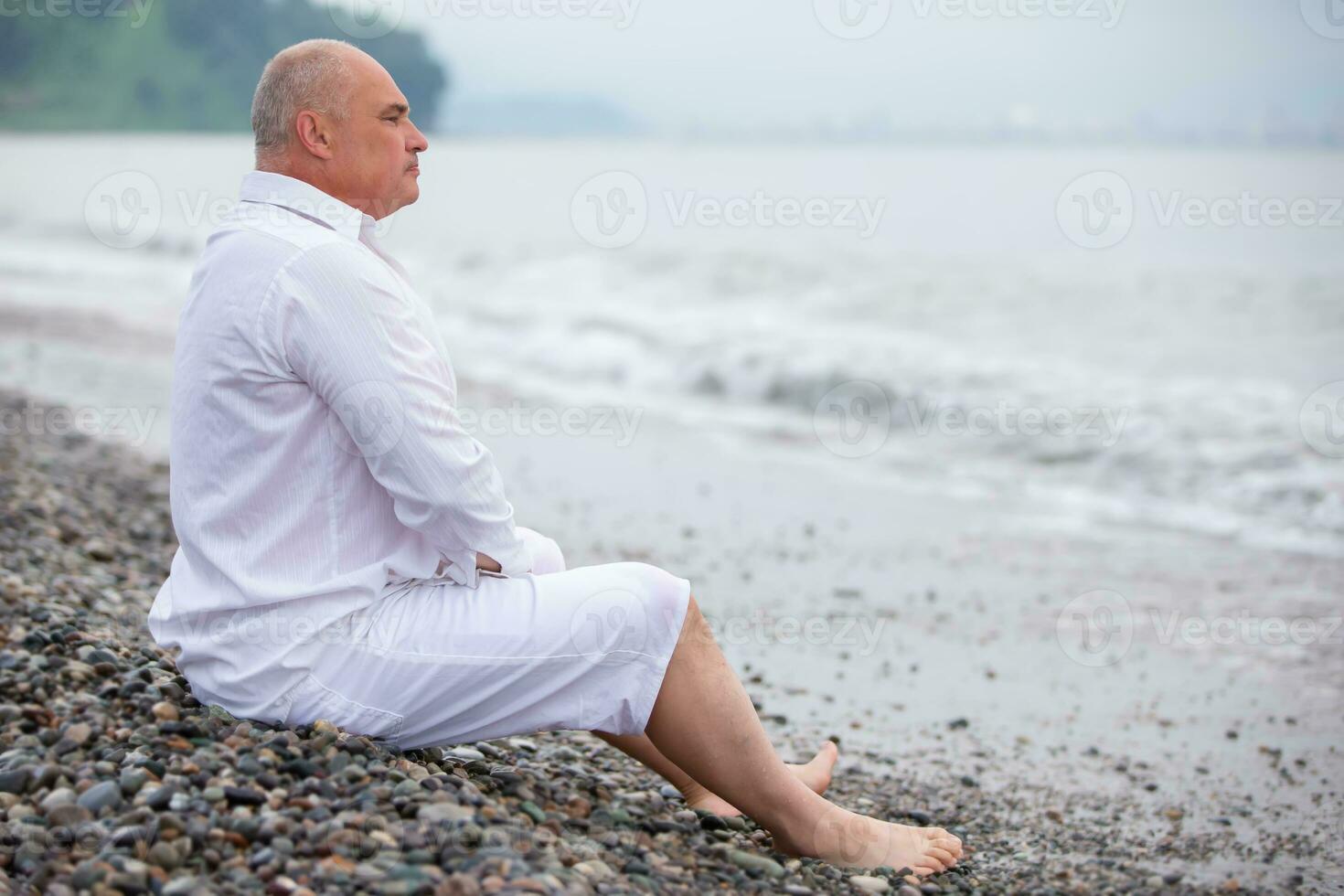 mayor hermoso atlético hombre mira a el mar ondas. foto