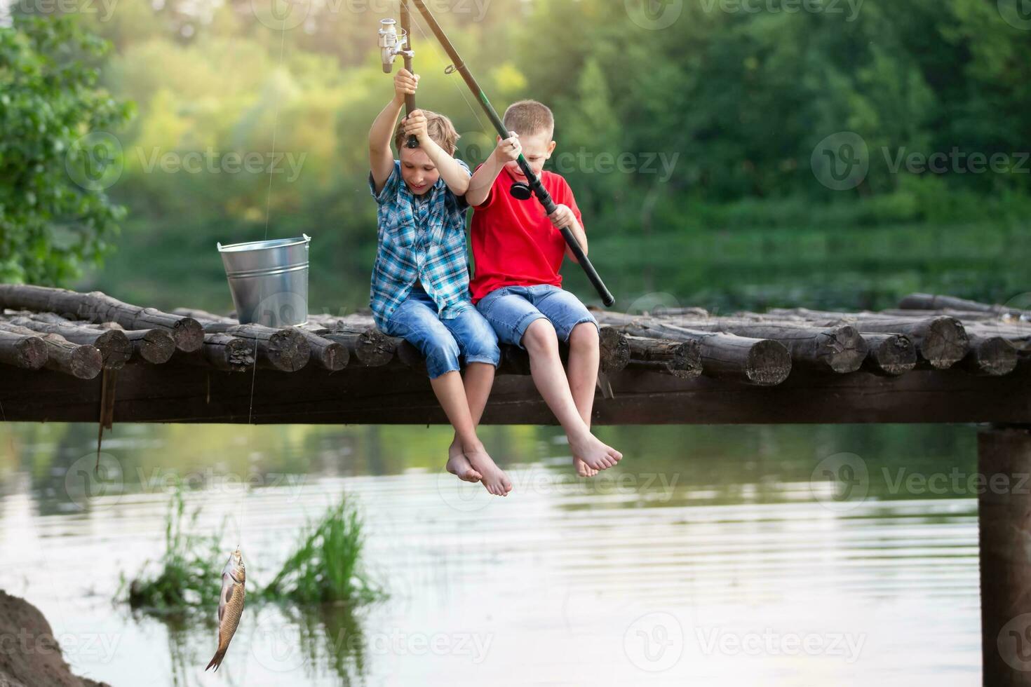 Happy friends boys caught a fish with a fishing rod. 35219570