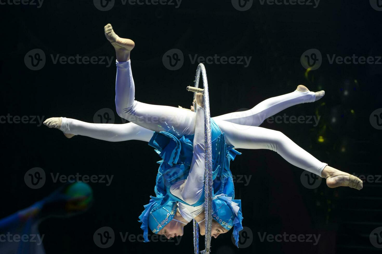 Two acrobat girls show a circus number on a dark background. Acrobatic performance. photo