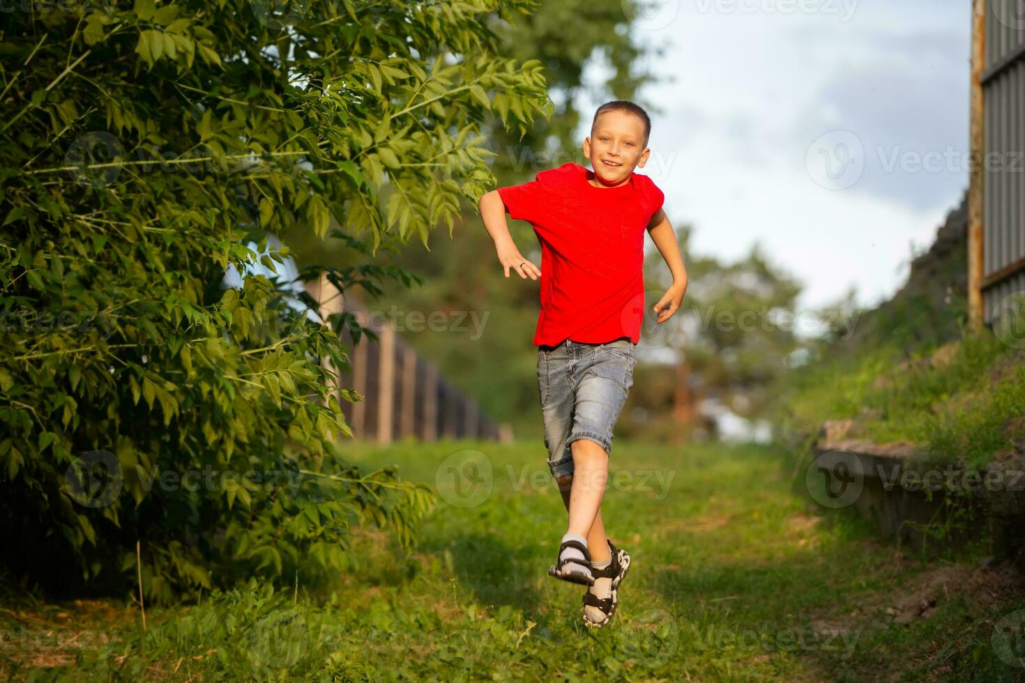 un contento chico carreras a lo largo un verano camino. foto