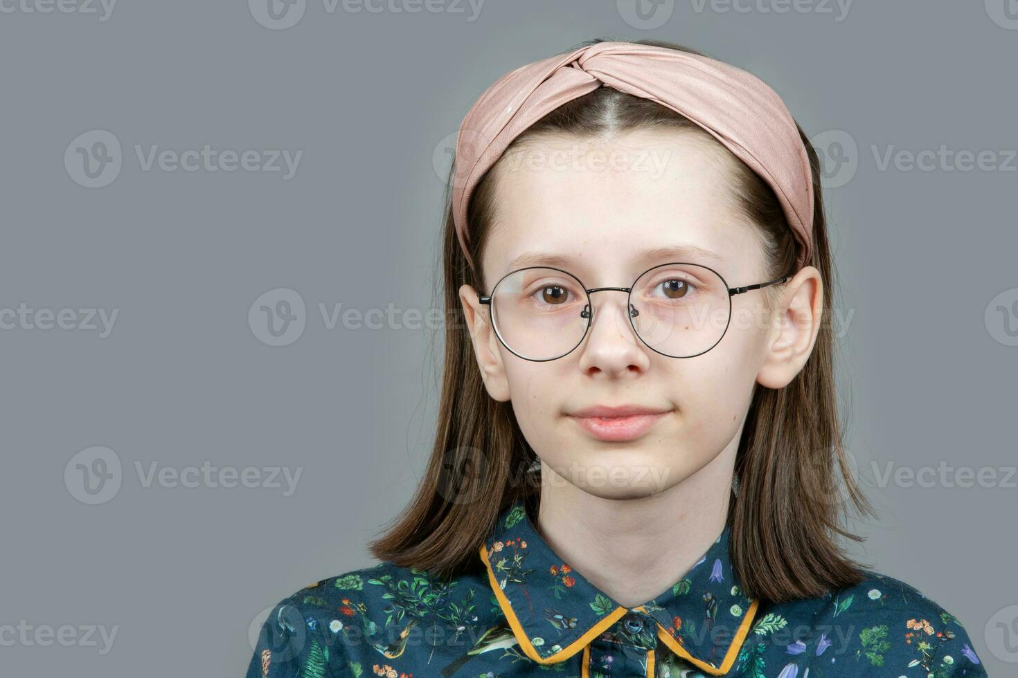 gracioso nerd niña en lentes mira inteligentemente dentro el cámara. foto