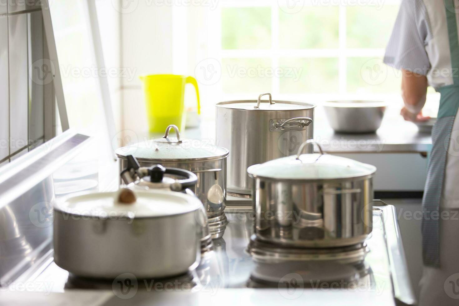 Metal pans in an industrial kitchen. Cooking on a professional stove. photo