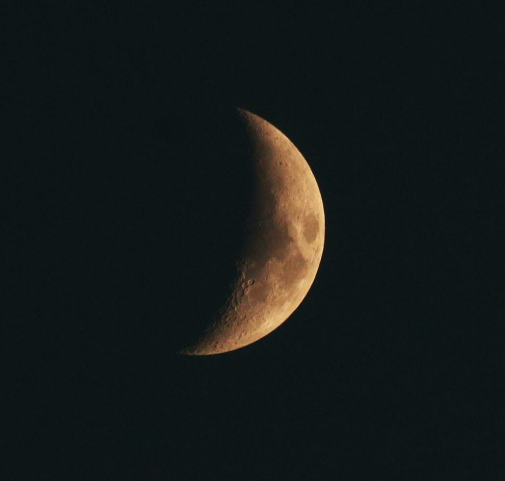 Moon half covered by shadow in the black sky. photo