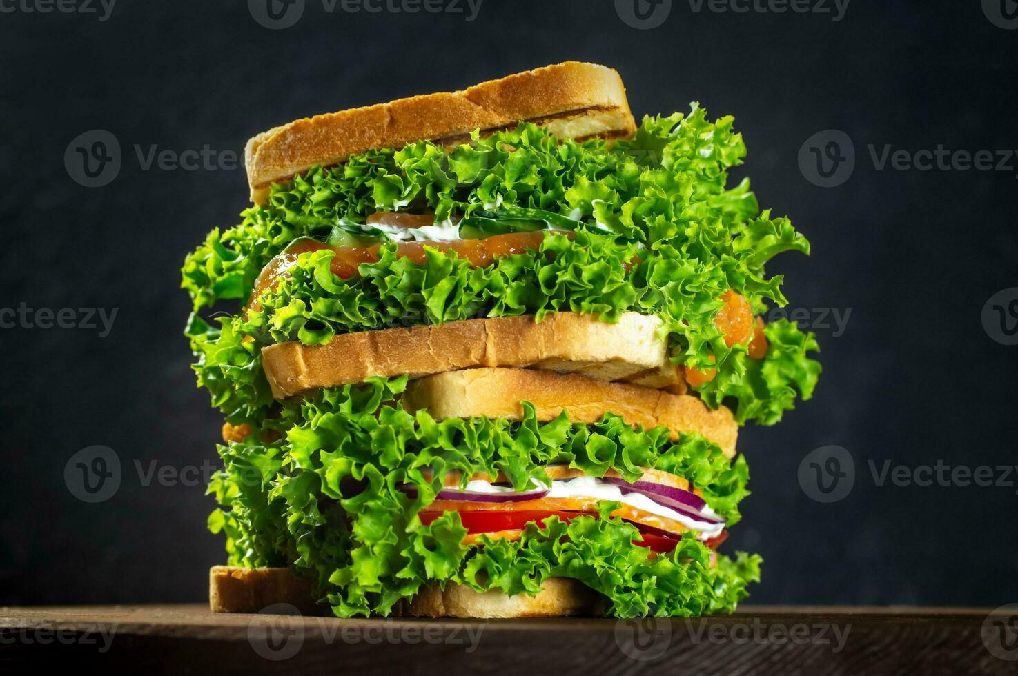 set of sandwiches with fresh salmon, ham, vegetables, salad. Home-made sandwiches. Healthy fast food. Dark background. photo