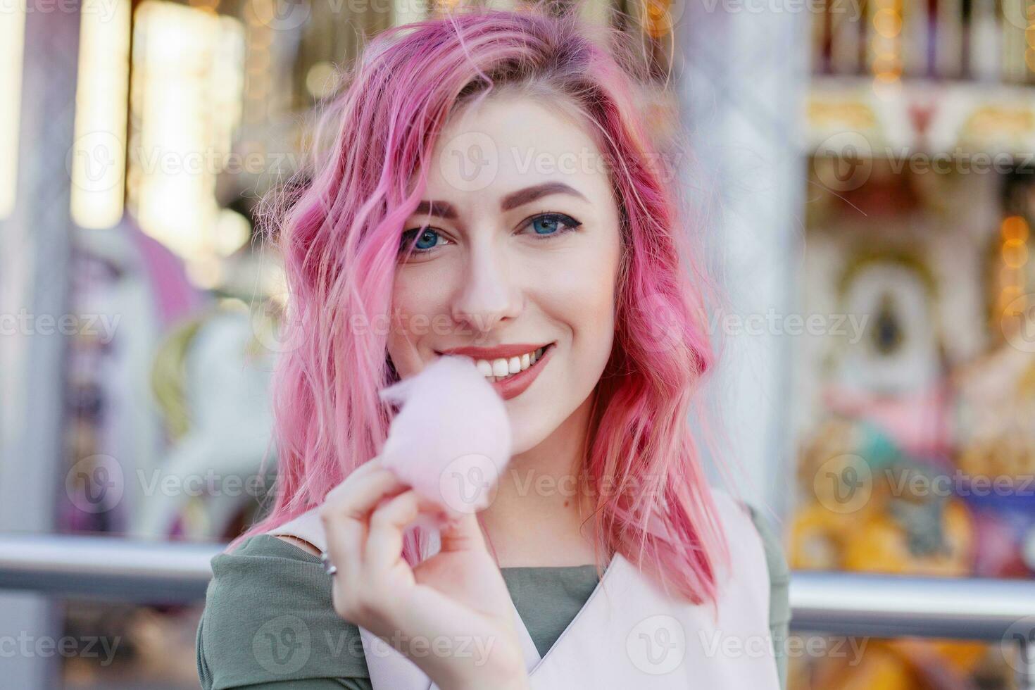 pink hair girl short haircut posing in amusement park on carousel background. photo